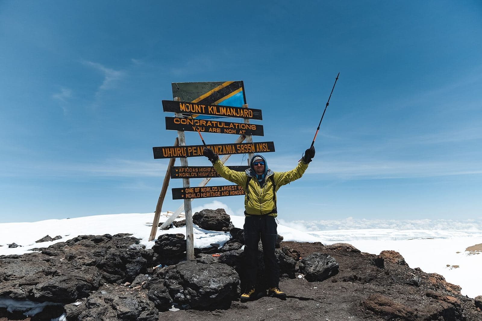 Climber celebrating at the Uhuru Peak sign