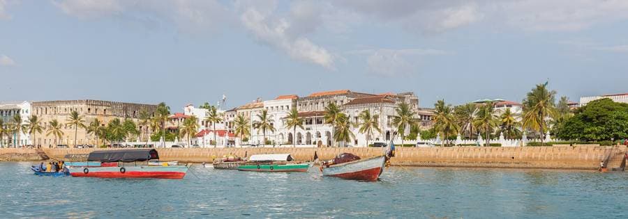 Stone Town waterfront in Zanzibar with boats in the harbour